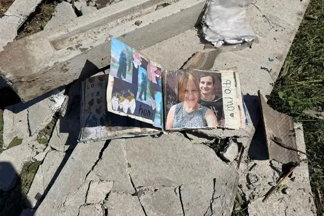A scrapbook with photos is seen among the debris of the house